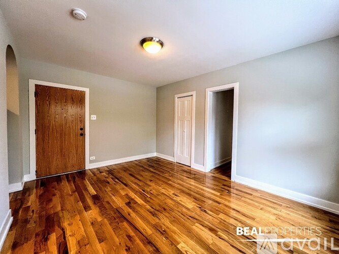 A room with wooden floors and a brown door.