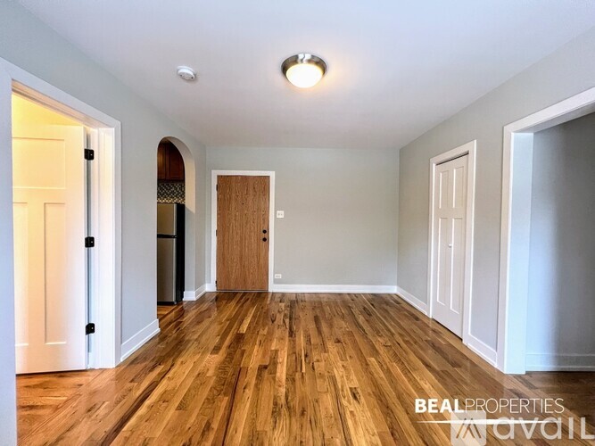 A spacious room with wooden floors and white walls.
