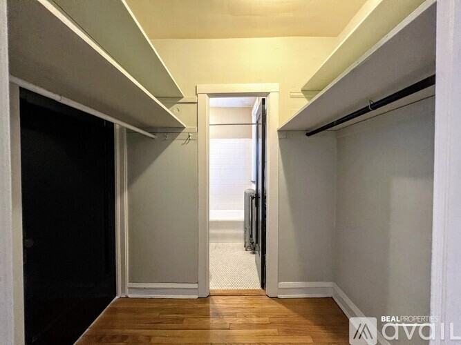 A hallway with a black door on the left and a white door on the right.