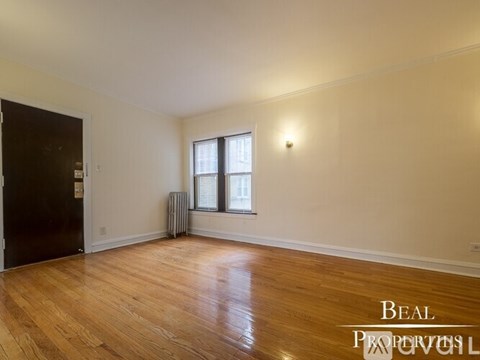 A room with wooden floors and a window with a white frame.
