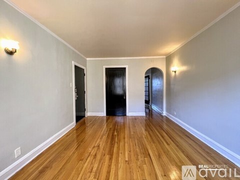 A hallway with wood floors and white walls.