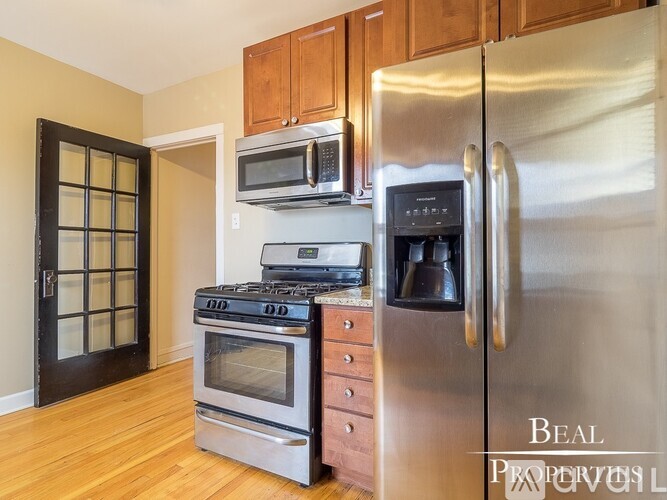 A kitchen with a stainless steel refrigerator, oven, and microwave.