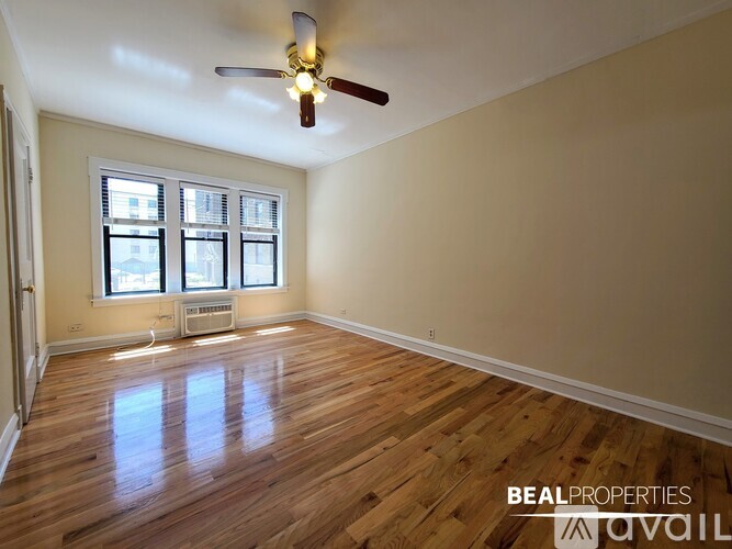 A room with wooden floors and a ceiling fan.