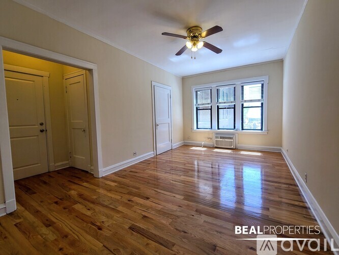 A room with wooden floors and a ceiling fan.