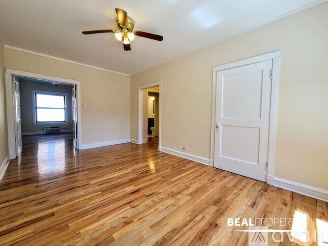 A room with wooden floors and a ceiling fan.