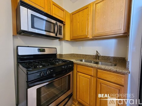 A kitchen with a black stove and a black microwave above it.