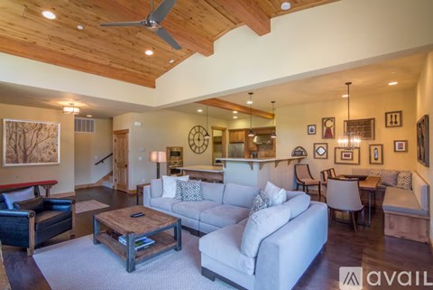 A living room with a white couch and a wooden coffee table.