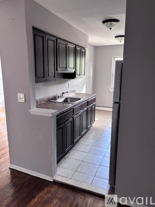 A kitchen with dark wood cabinets and a white countertop.
