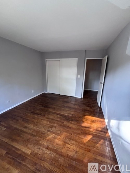 A room with wooden flooring and two doors.