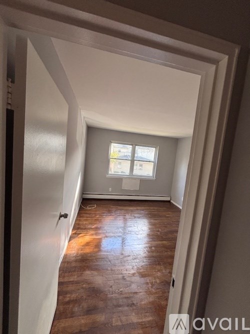 A room with a wooden floor and a window.