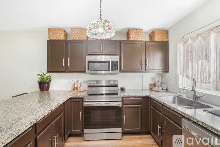 A kitchen with brown cabinets and granite countertops.