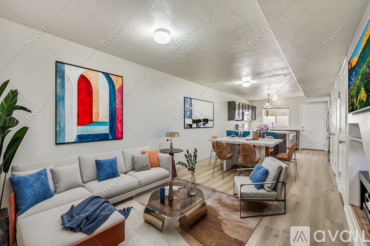A living room with a grey sofa, a coffee table, and a painting on the wall.