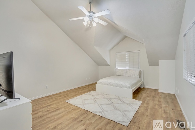 A bedroom with a bed and a ceiling fan.