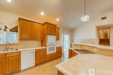 A kitchen with wooden cabinets and a large island.