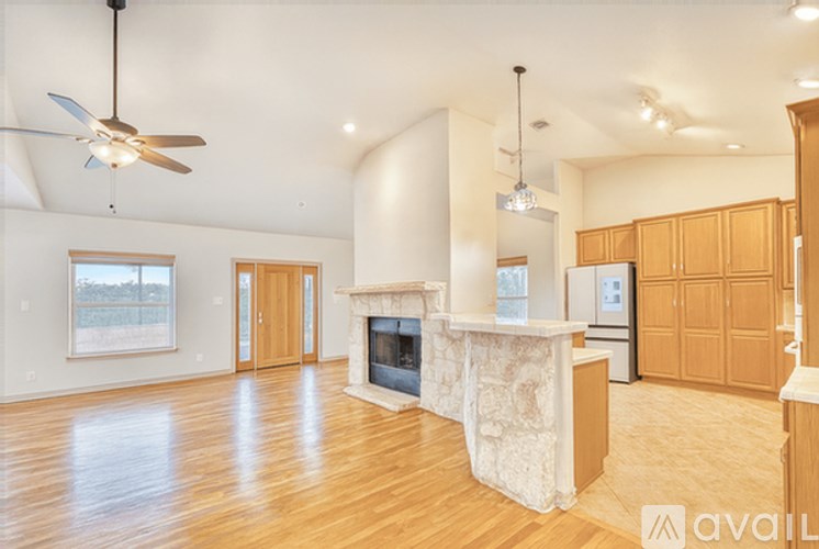 A spacious living room with a fireplace and wooden floors.