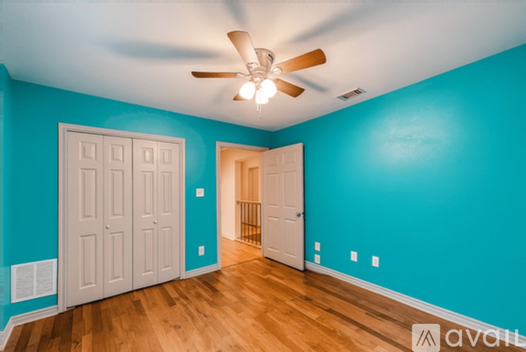 A room with a ceiling fan and two doors.