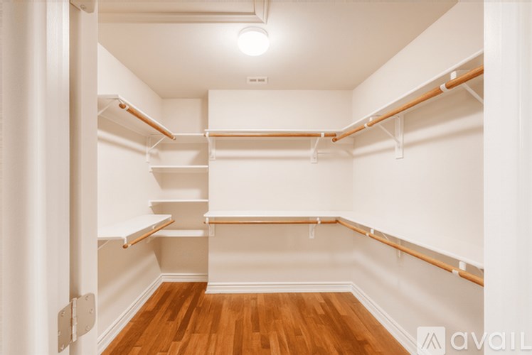 A white room with wooden floors and a white wall with a white ceiling and a white door.