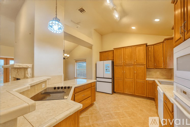 A kitchen with wooden cabinets and a white fridge.