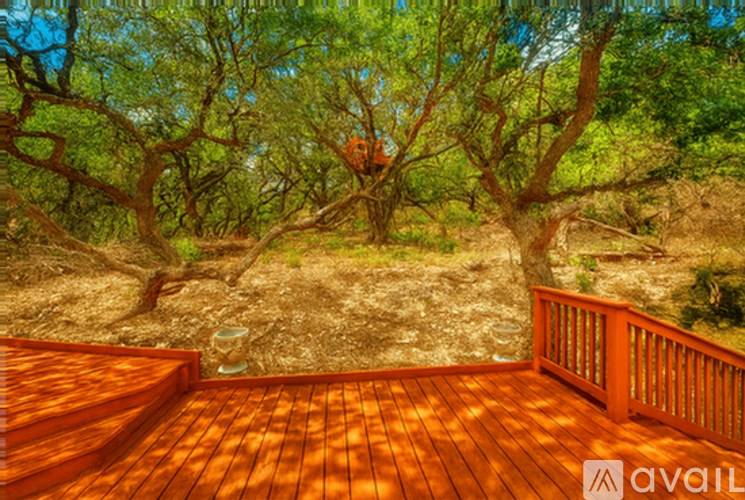 A wooden deck overlooks a tree-filled landscape.