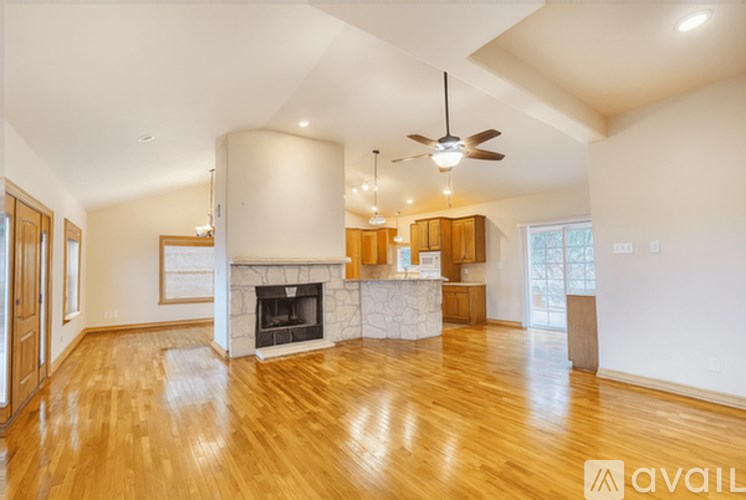 A spacious living room with a fireplace and wooden floors.