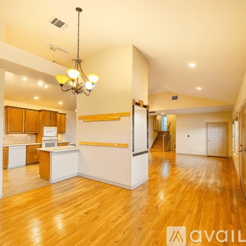 A large open space with wooden floors and a kitchen area.