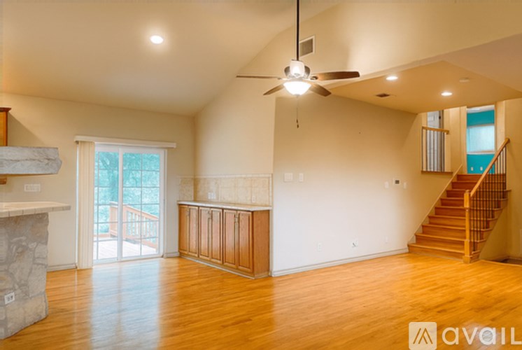 A spacious living room with a fireplace and a staircase.