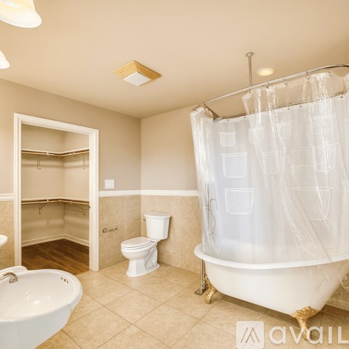 A bathroom with a white tub, toilet, and sink.