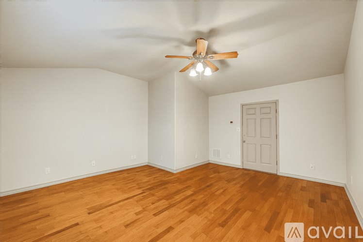 A room with wooden floors and a ceiling fan.