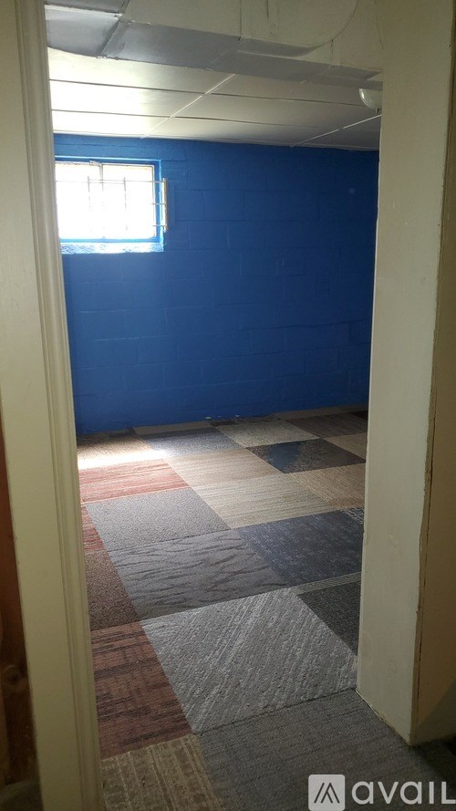A room with a blue wall and a window.