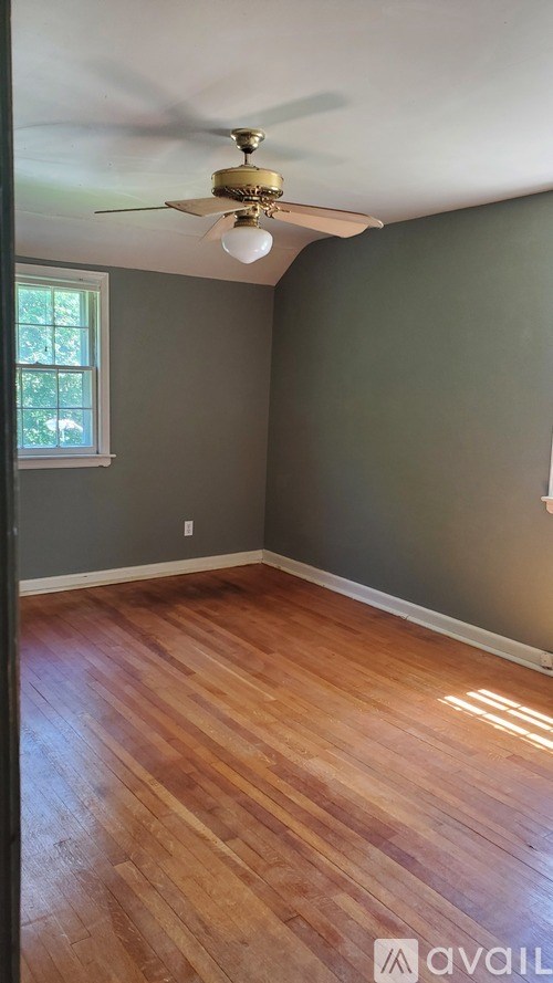 A room with a ceiling fan and a window.