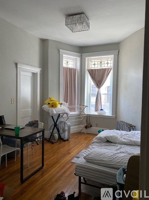 A room with a bed, desk, and chair.