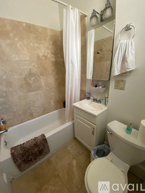 A bathroom with a tub, toilet, and sink.