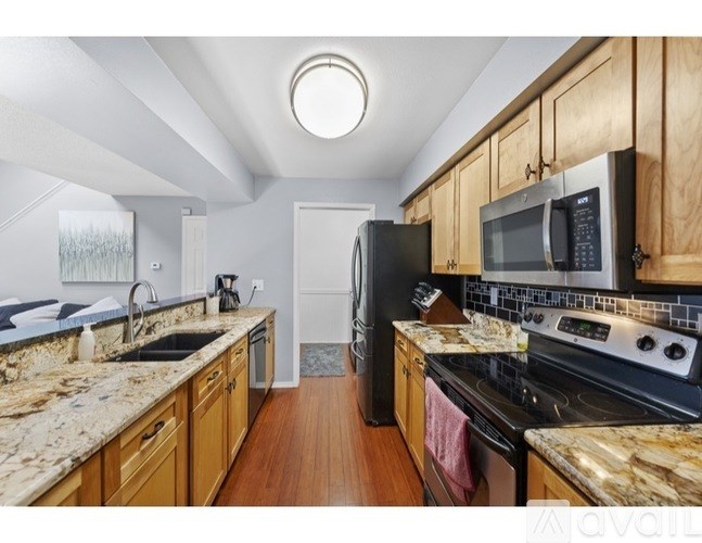 A kitchen with wooden cabinets and granite countertops.