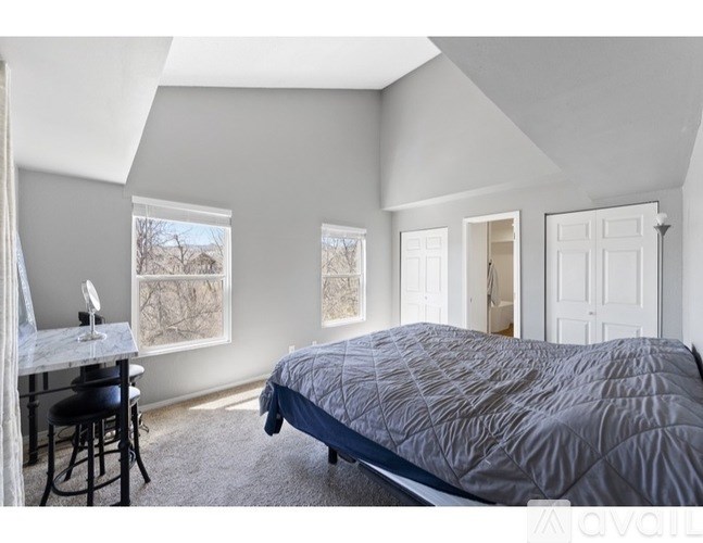 A bedroom with a bed, desk, and chair.