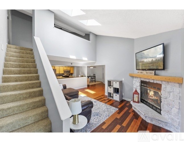 A living room with a fireplace and a television on the wall.