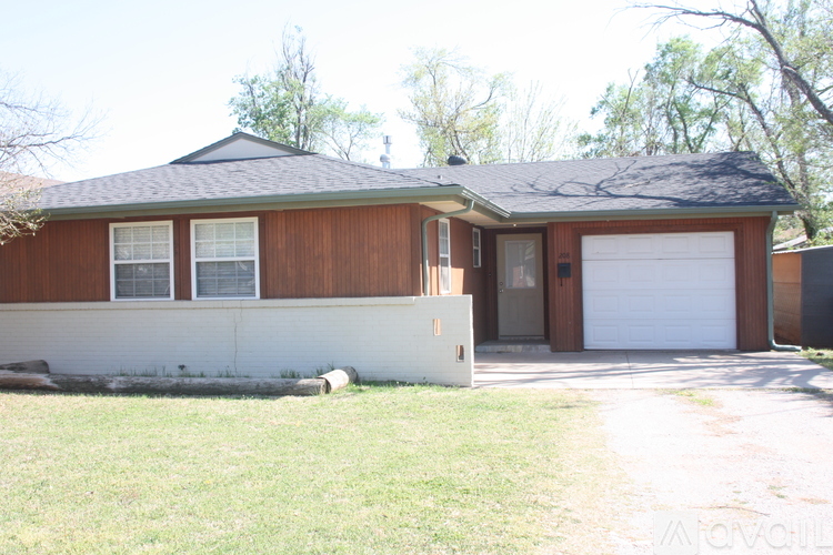 A brown house with a white garage door.