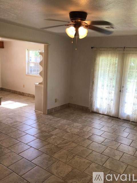 A room with a ceiling fan and tiled flooring.