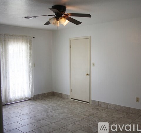 A room with a ceiling fan and a door.