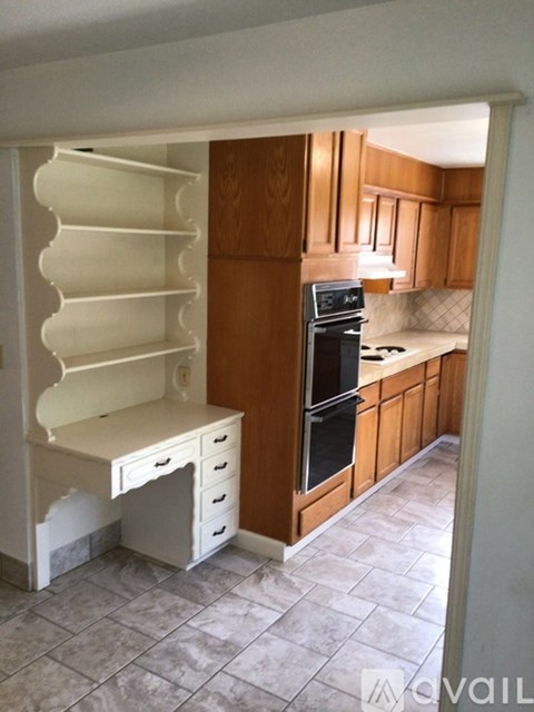 A kitchen with wooden cabinets and a black stove top oven.