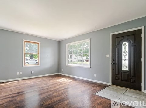 A room with a wooden floor and a black door.