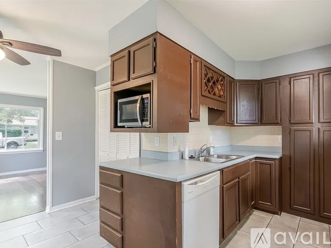 A kitchen with brown cabinets and a white dishwasher.