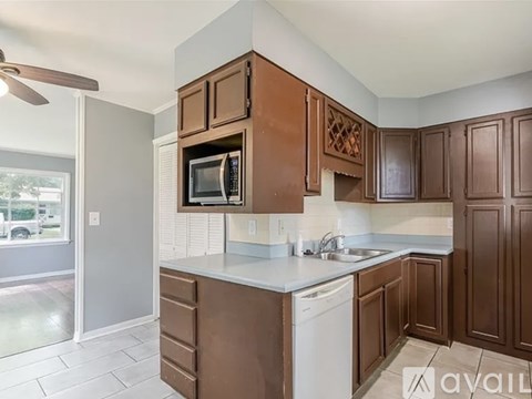 A kitchen with brown cabinets and a white dishwasher.