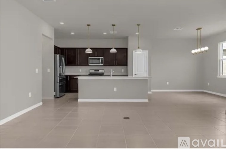A spacious kitchen with a refrigerator, microwave, and oven.