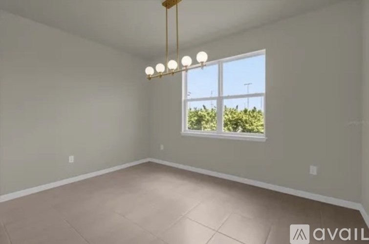A room with a large window and a chandelier.
