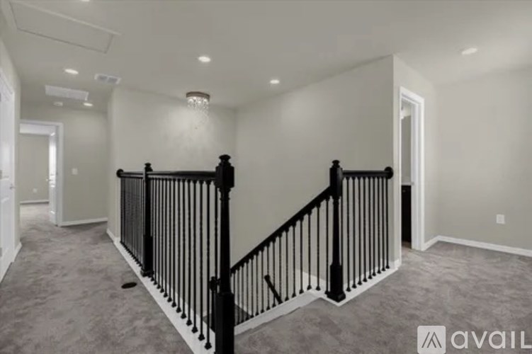 A spacious room with a staircase and a carpeted floor.
