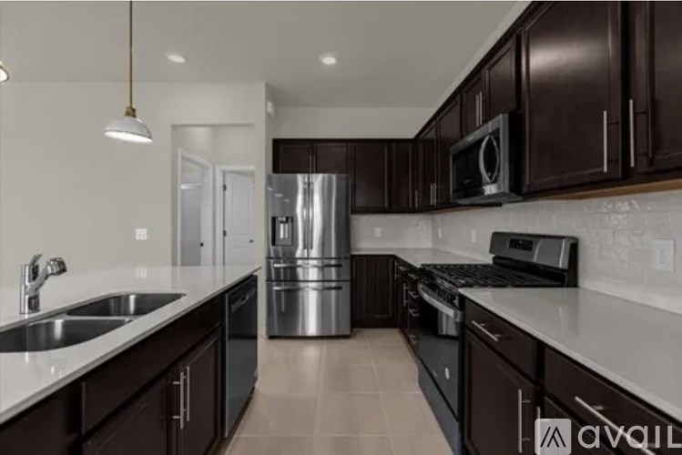 A kitchen with dark brown cabinets and stainless steel appliances.