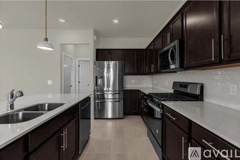 A kitchen with dark brown cabinets and stainless steel appliances.