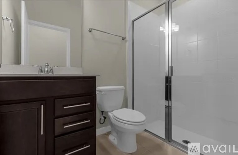 A white toilet sits in a bathroom next to a walk-in shower.