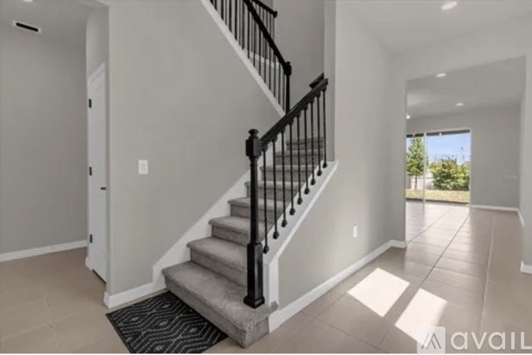 A staircase with a black railing and a beige carpeted runner.
