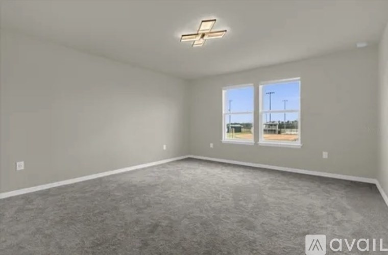 A spacious room with a carpeted floor and a large window.